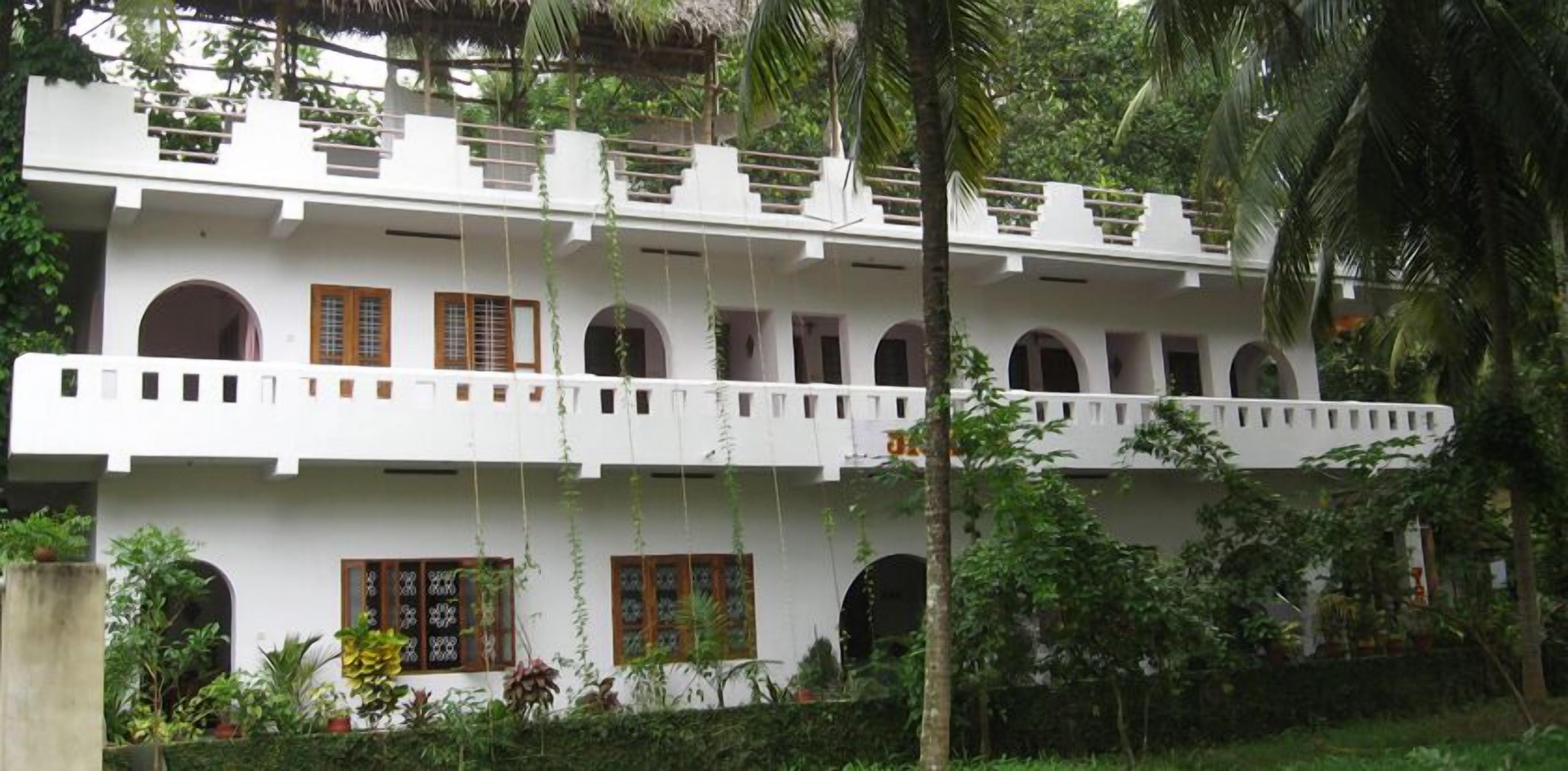 A two-story building with multiple arched windows and a balcony.