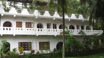A two-story building with multiple arched windows and a balcony.