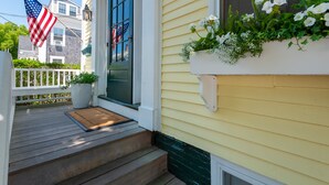 A house with a front porch, a mailbox, and a door with a window. - Periwinkle Inn (Nantucket)