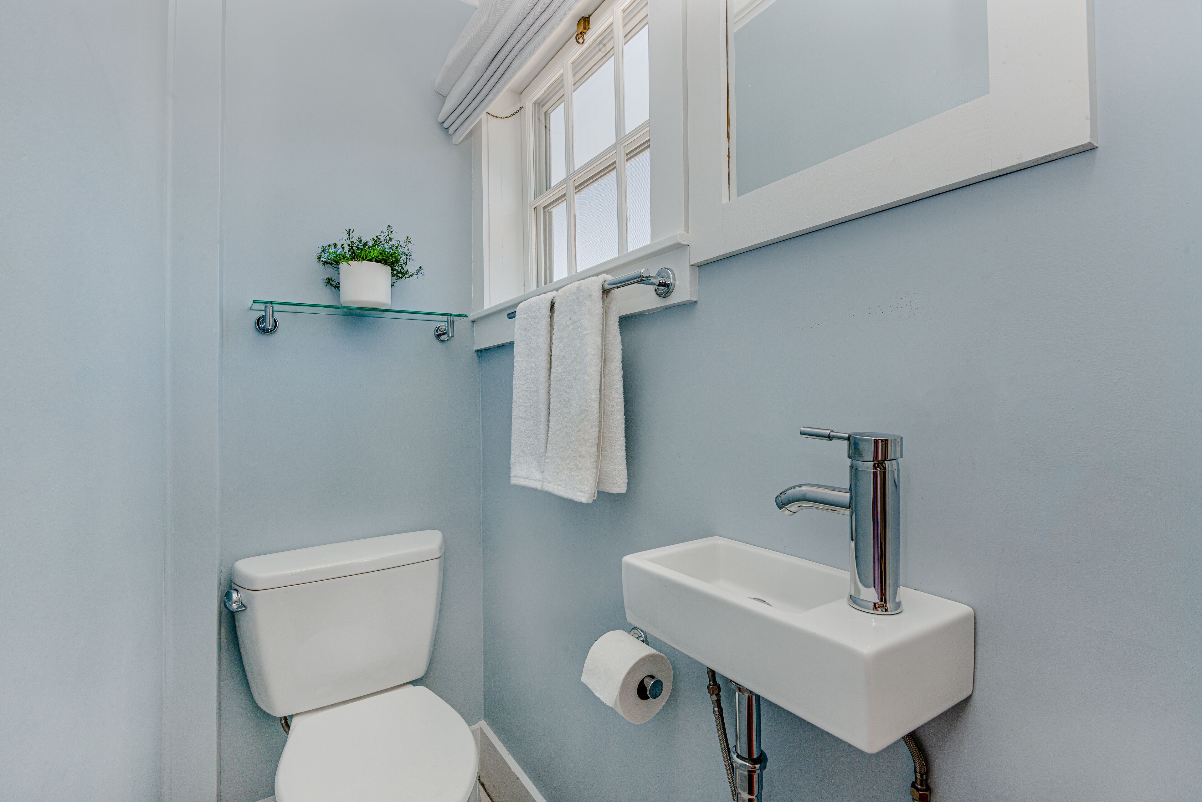Ein Badezimmer mit Toilette, Waschbecken und einem kleinen Fenster.