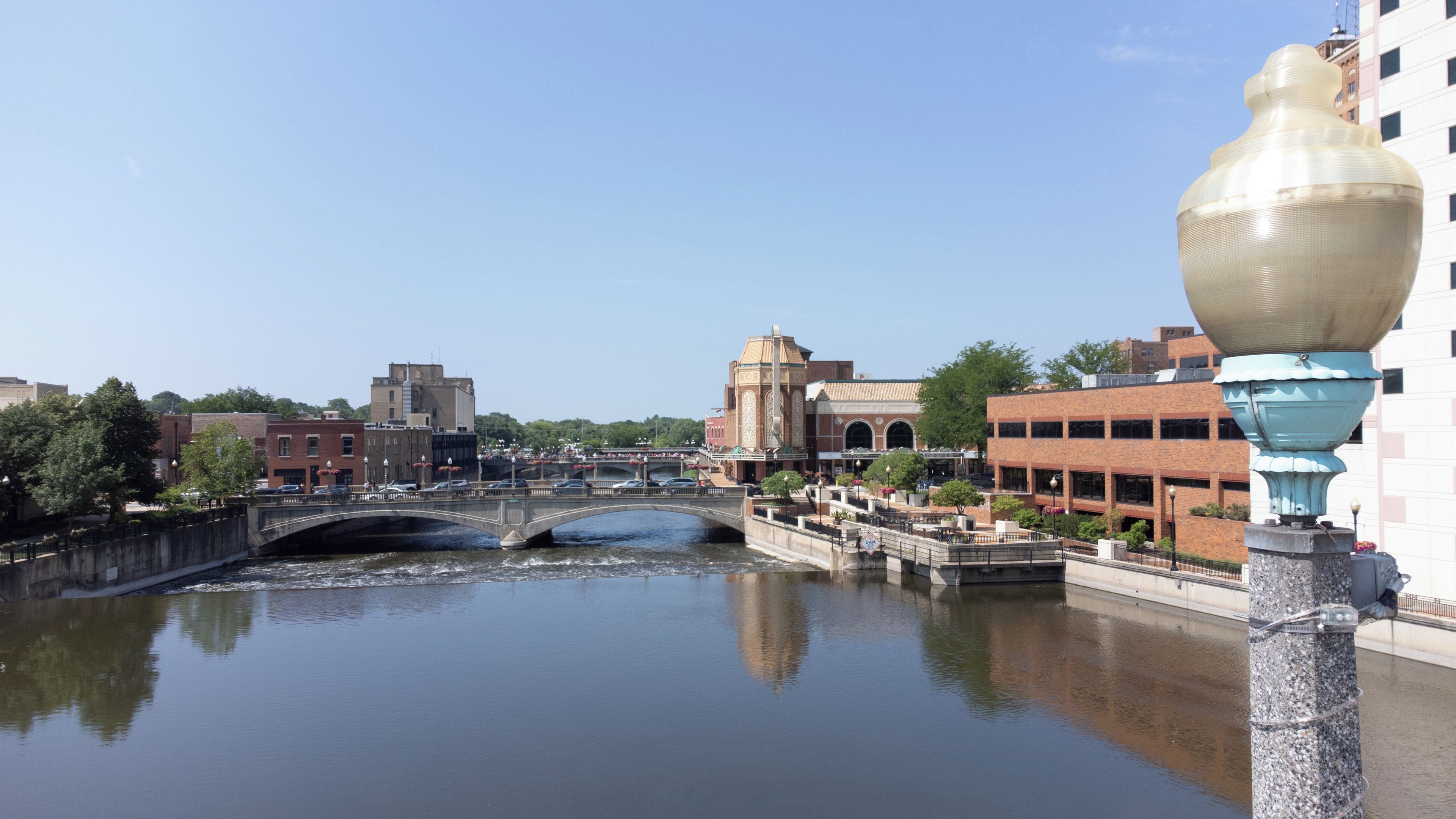 A river with a bridge, buildings, and a large decorative urn.