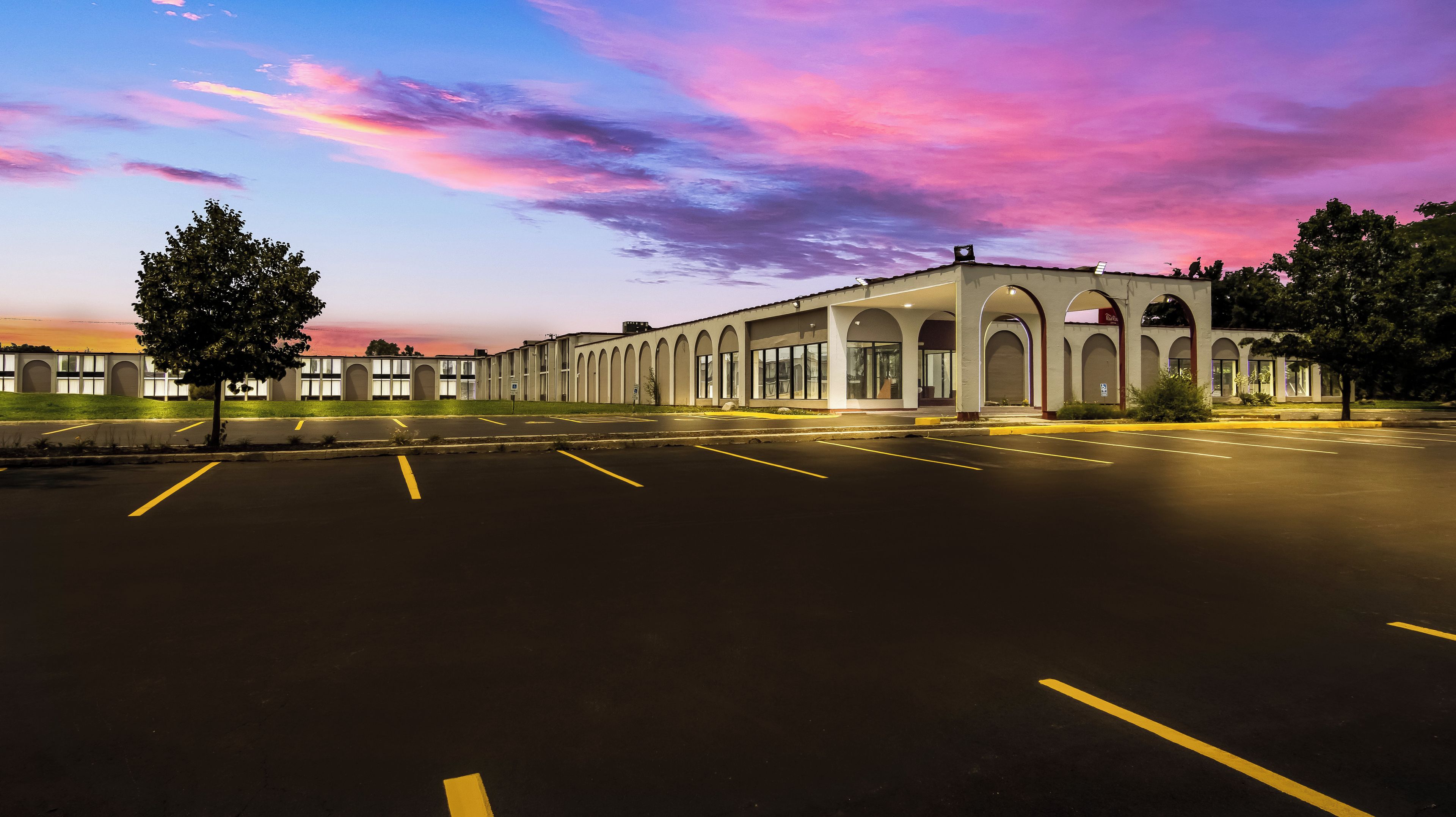 A building with a row of arched windows and a parking lot.