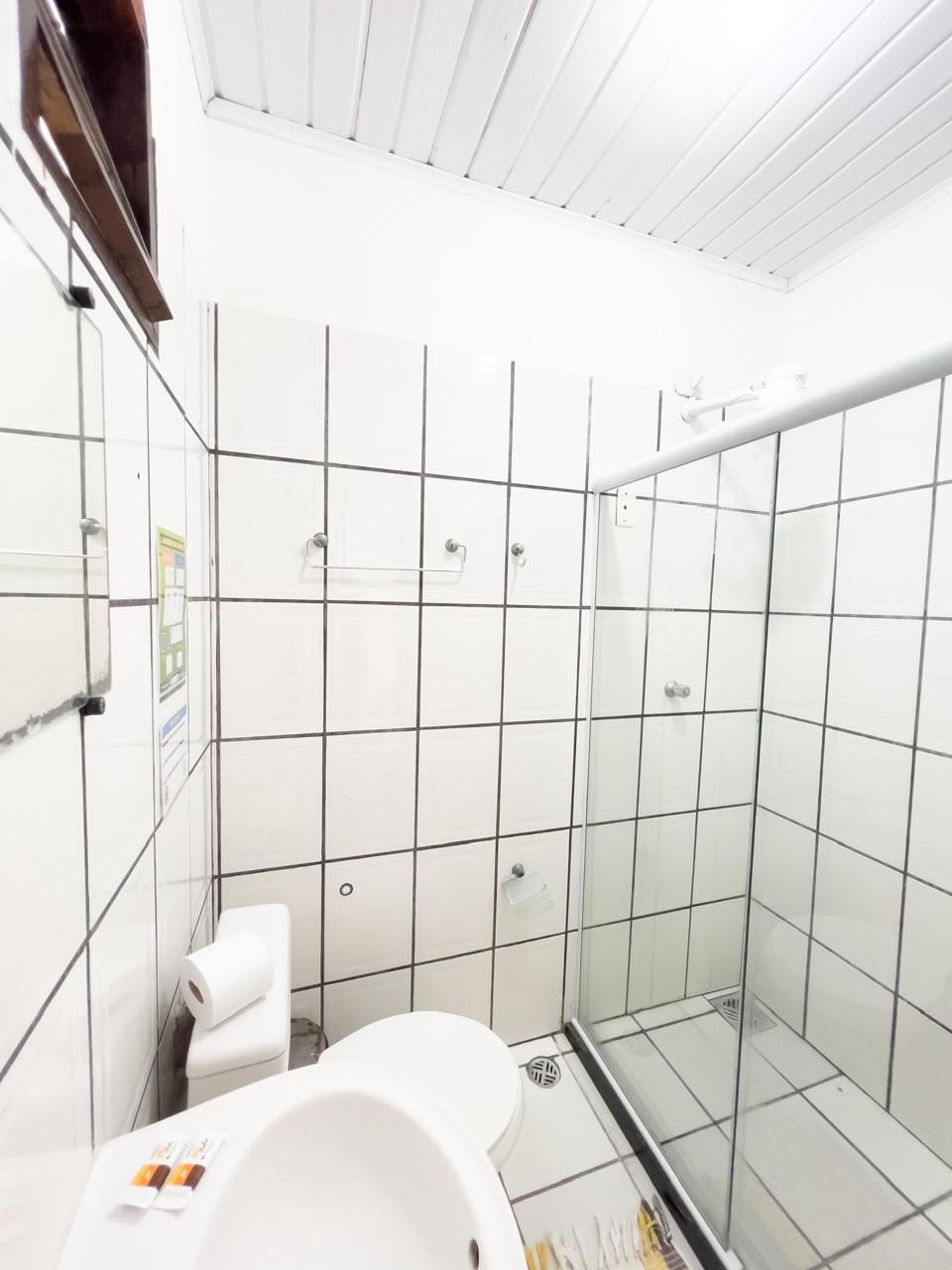 A bathroom with a toilet, a shower stall, and a glass door.