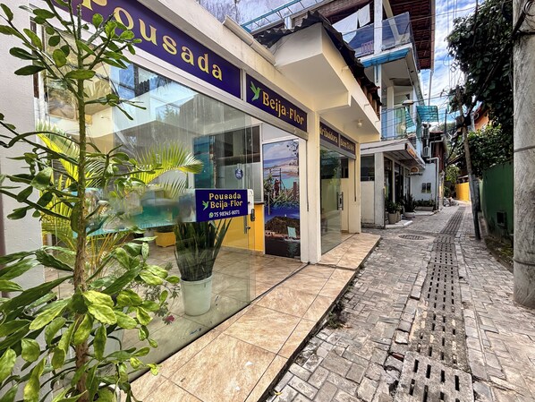 Fachada con un letrero que dice 'Pousada Beija-Flor' y un número de contacto.