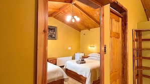 Een hotelkamer met twee bedden, een houten plafond en een grote spiegel die de kamer weerkaatst.