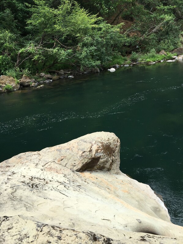 Un río con agua cristalina, rodeado de rocas y follaje.