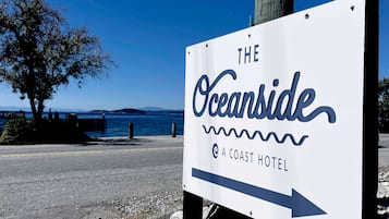 A sign for The Oceanside Coast Hotel with an arrow pointing to the right, indicating the direction to the hotel.