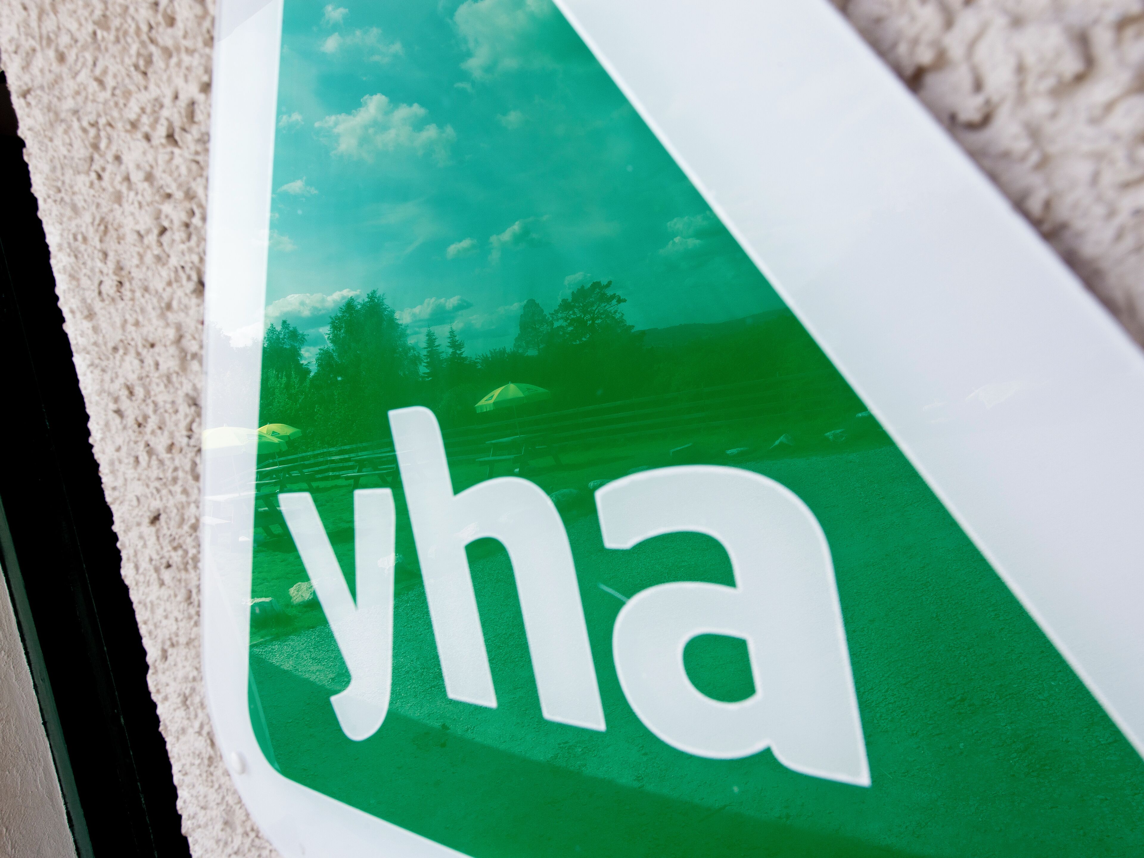 A close-up of a green and white sign with the text "yha".