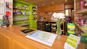 Un espace bar avec un plafond en bois, des étagères remplies de bouteilles et de verres, et une carte posée sur le comptoir.