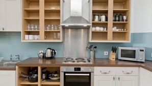 Een moderne keuken met houten kastjes, roestvrijstalen apparatuur en een ingebouwde oven.
