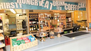 Een koffiebar met een bord waarop staat: HUNGRY AT DRINK COFFEE CAKE.