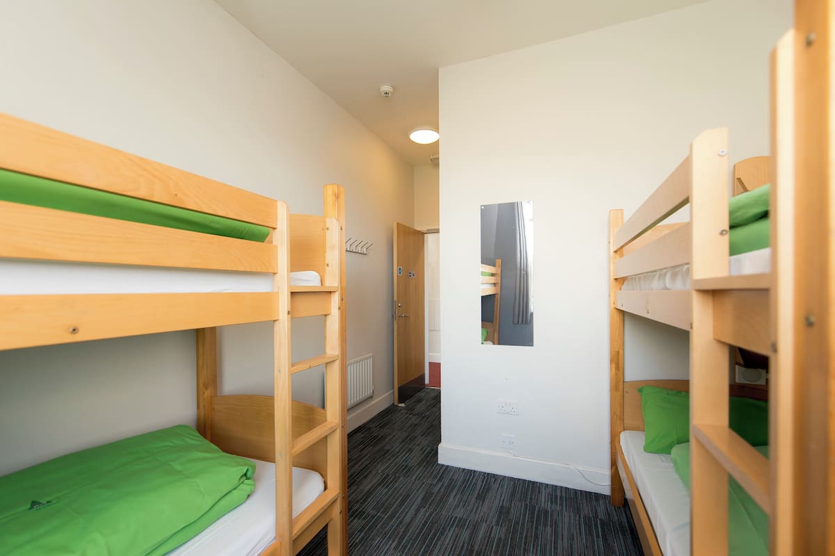 Ein Zimmer mit Etagenbetten, einer Heizung und einer Tür.
