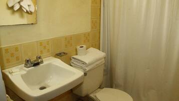 Ein Badezimmer mit Waschbecken, Toilette und einem Handtuch an der Wand.