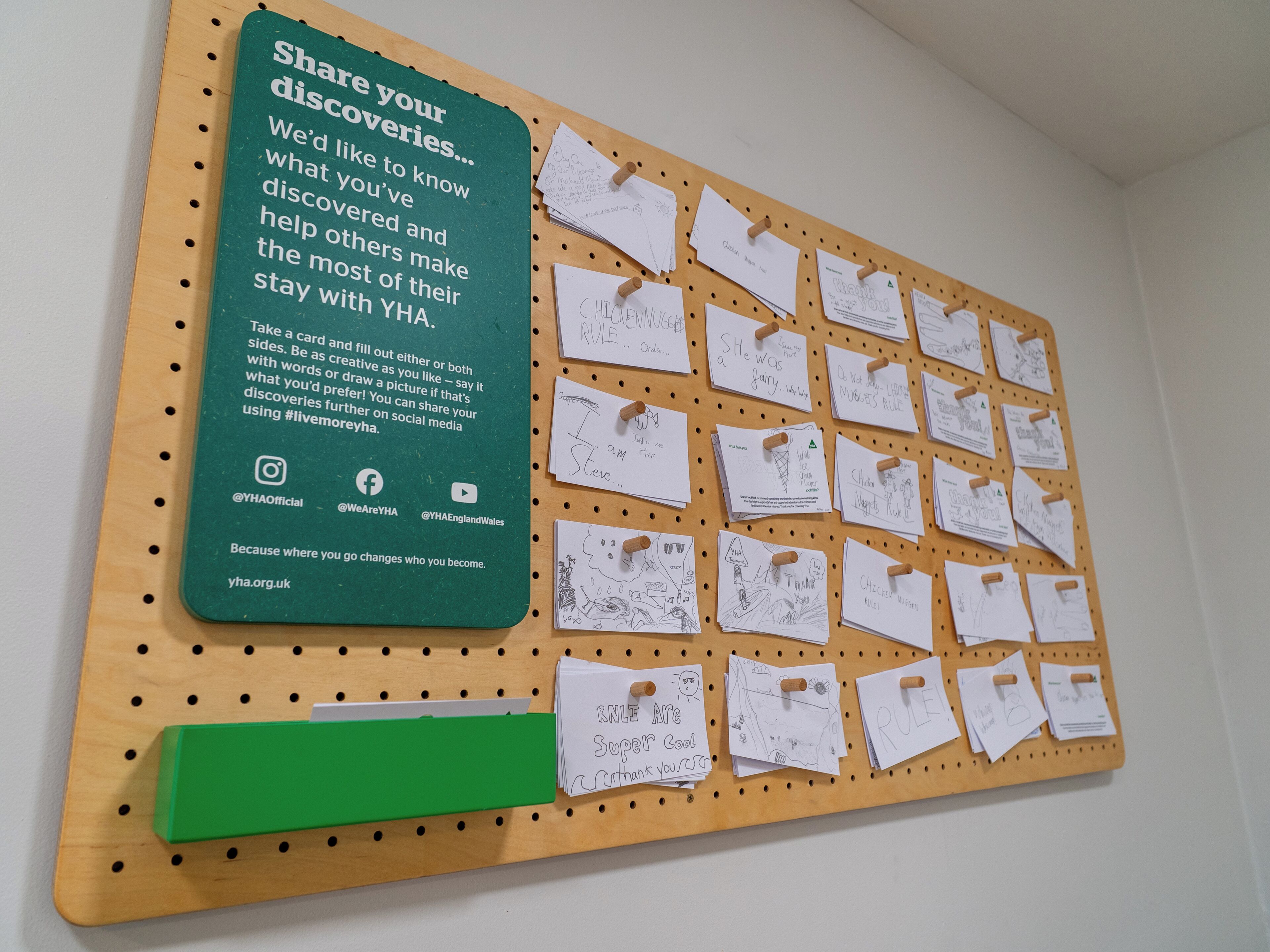 Een prikbord met vastgepinde briefjes en een groen bord.