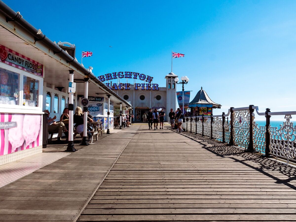A wooden pier with shops and a sign reading "Brighton Pier".