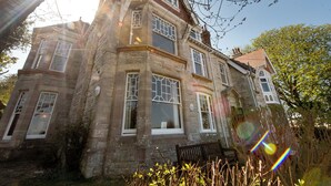 A stone building with multiple windows and a prominent corner tower. - YHA Swanage - Hostel (Swanage)