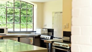 Una cocina con ventana, microondas, tostadora y horno.