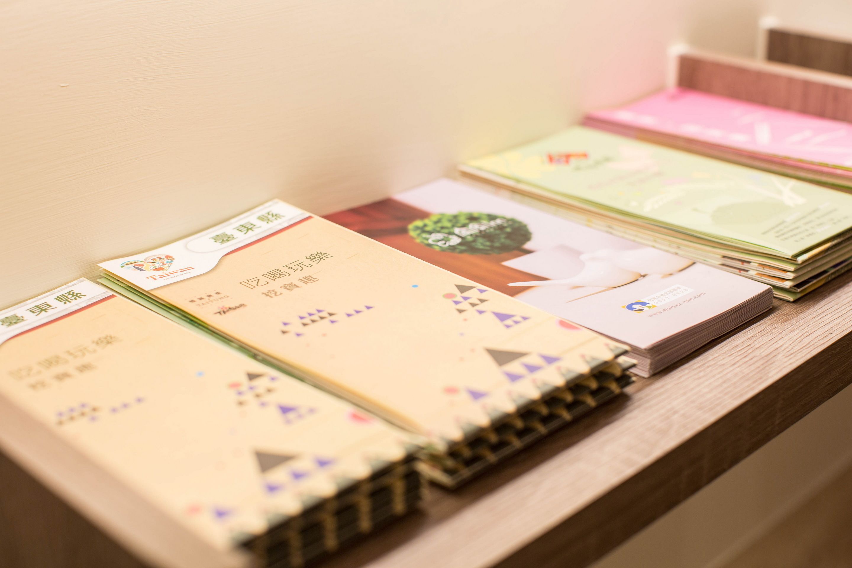 A stack of books with visible text and images on a wooden surface.