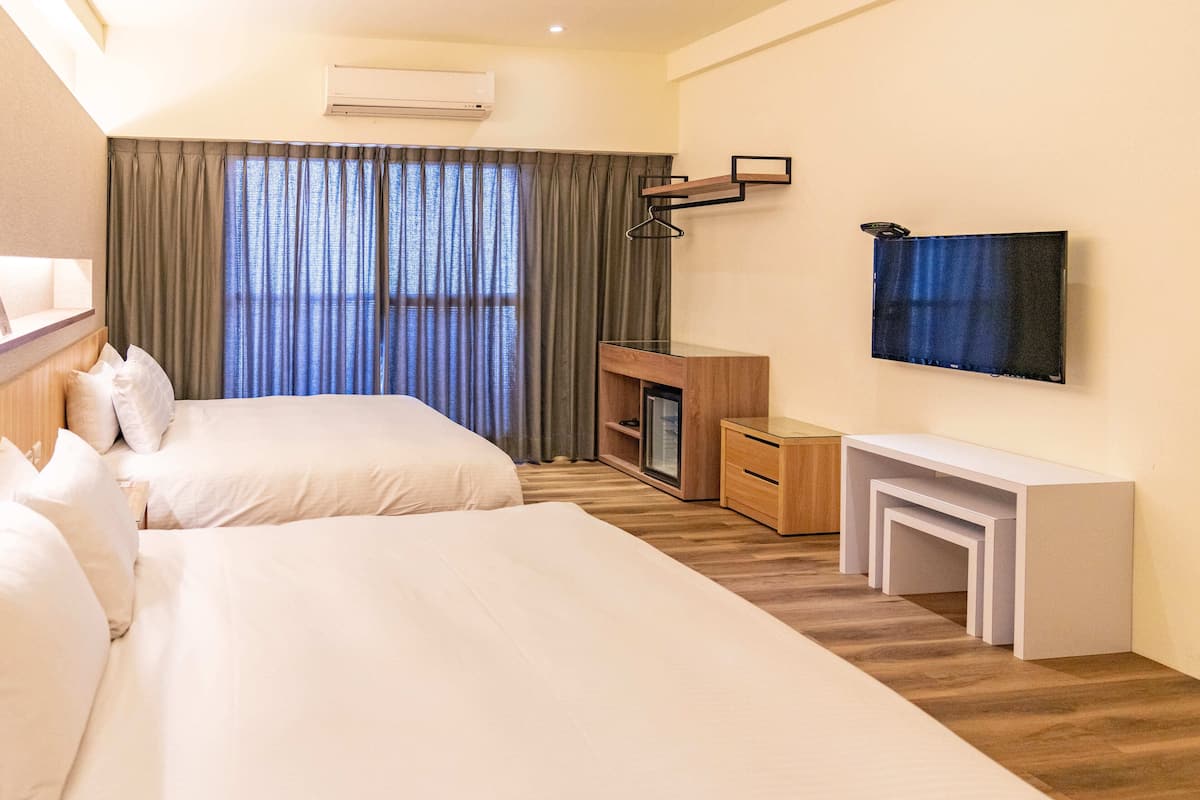 Habitación cuádruple Deluxe | Ropa de cama de alta calidad, artículos del minibar gratis y escritorio