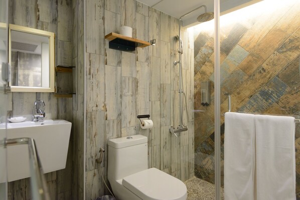 A bathroom with a toilet, sink, and shower.