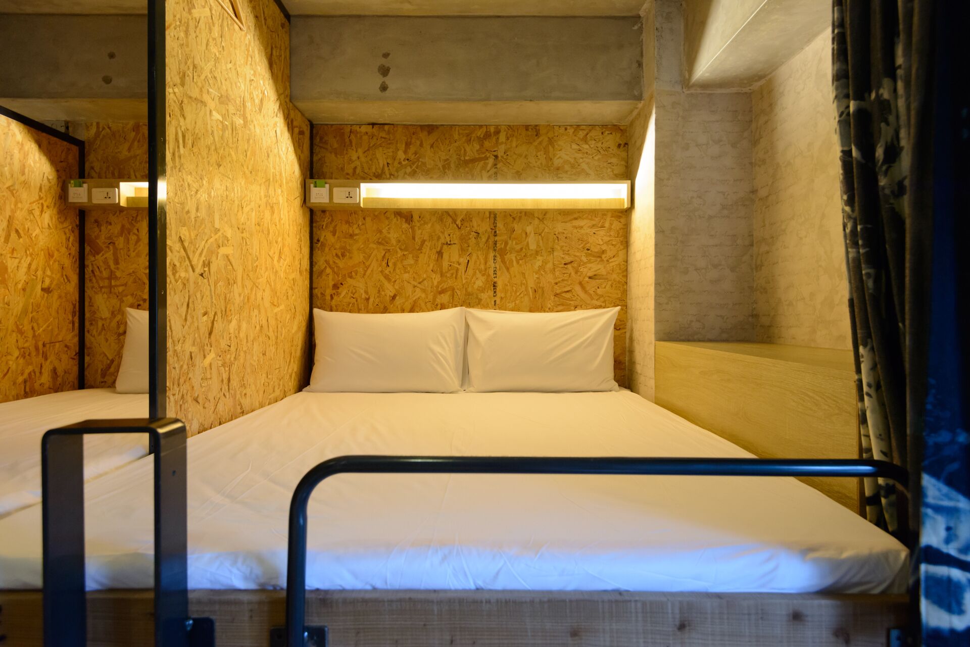 Una cama litera con cabecera de madera y estructura metálica.