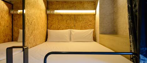 Una cama litera con cabecera de madera y estructura metálica.