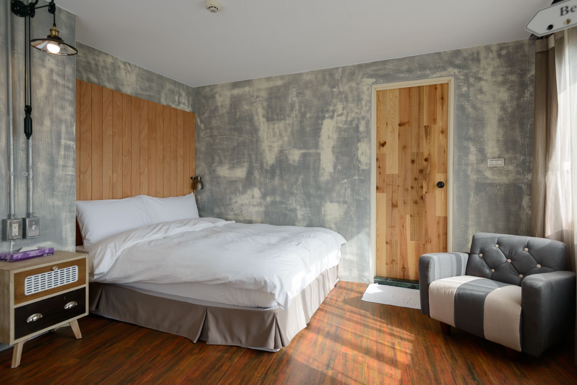 Une chambre à coucher avec un lit, une table de chevet, une lampe et une chaise.