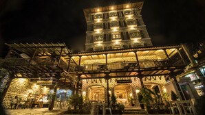 Um edifício de pedra com várias varandas e um espaço de varanda coberto.