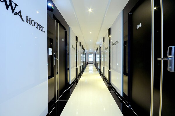 Un couloir d’hôtel avec des portes portant les inscriptions « WA HOTEL » et « 701 ».