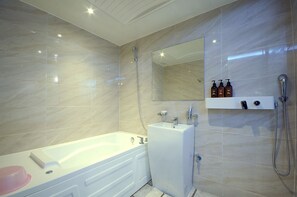 Enjoy a spacious bathroom with a large bathtub, separate shower, and sink.