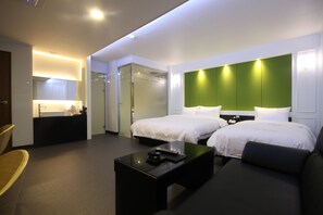 Relax in this stylish room with two single beds, a sofa, and a comfortable seating area.