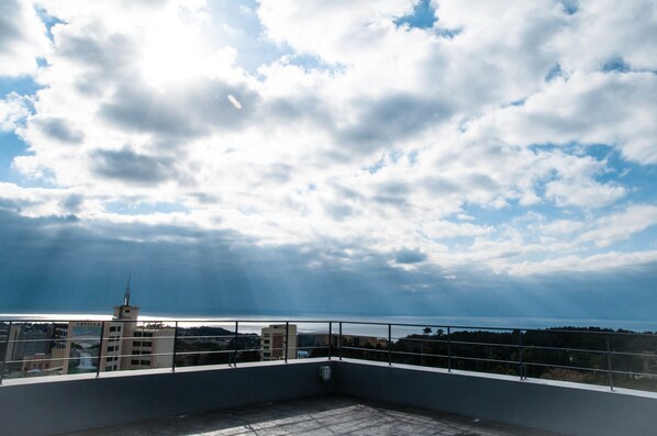 Une terrasse sur le toit offrant une vue sur la mer et les nuages.