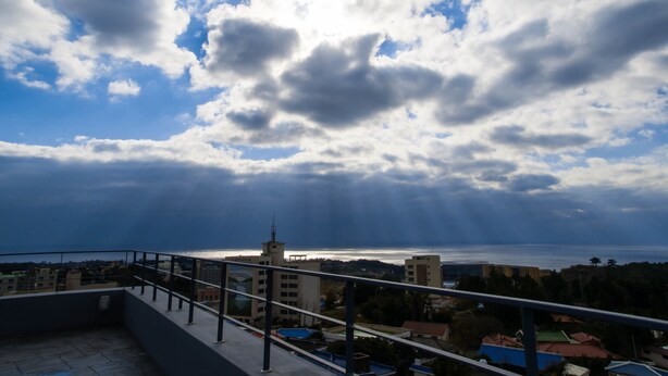 Un balcon avec vue sur la mer et les bâtiments.
