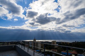 Un balcon avec vue sur la mer et les bâtiments.