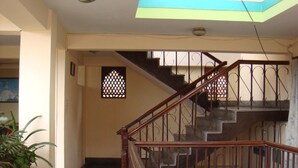 A staircase with wooden railings and a red carpet leading to an upper floor. - Hotel Hana (Kathmandu)