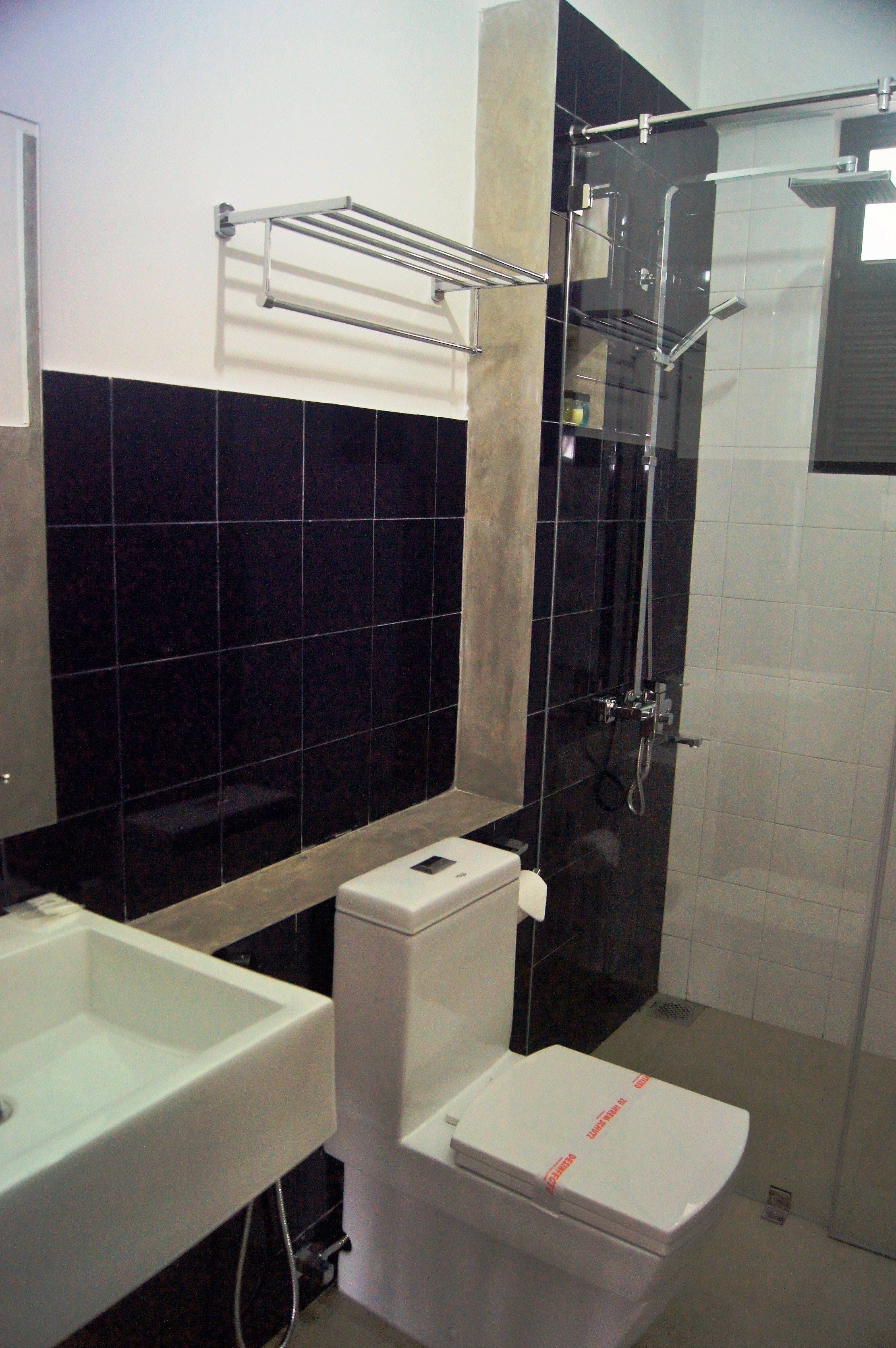Ein Badezimmer mit einem weißen Waschbecken, einer Toilette und einer Duschkabine.