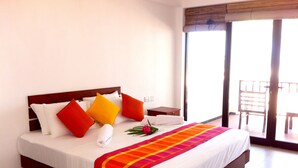 A hotel room with a large bed, a wooden headboard, and a balcony with a chair. - Wellé Wadiya (Kudawa)