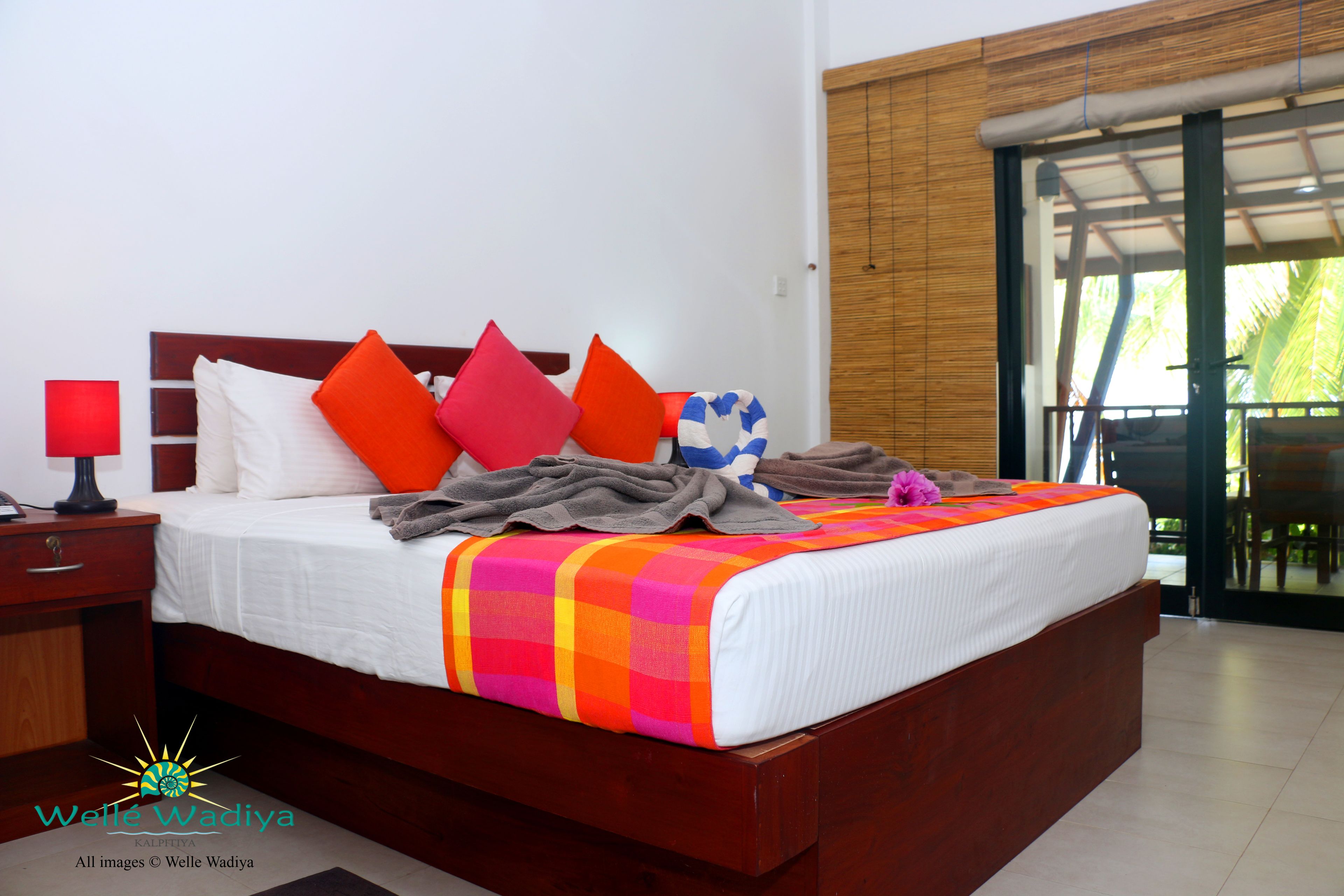 Una cama bien hecha con un edredón colorido, un cabecero de madera y varias almohadas.