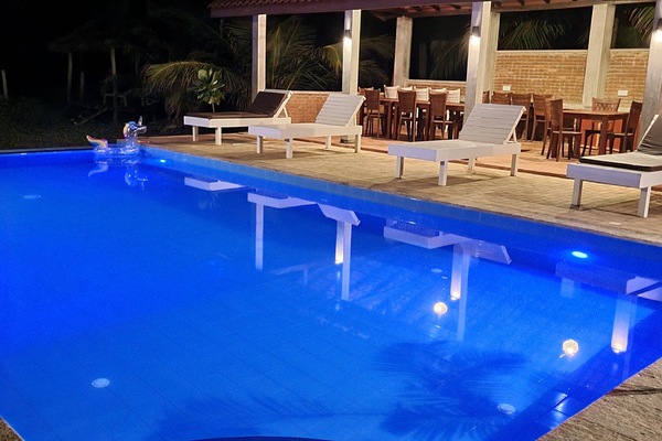 Una piscina al aire libre, una piscina con borde infinito, tumbonas