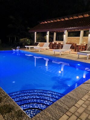 Utendørsbasseng, et evighetsbasseng og solsenger