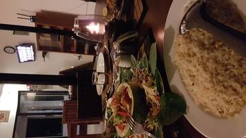 Uma mesa de jantar com um prato de comida, um copo e uma vela.