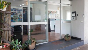 A hotel entrance with a glass door, potted plants, and a tiled floor. - Cairns City Motel (Cairns)