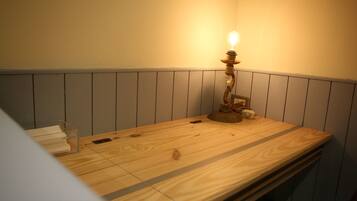 Una mesa de madera con un recipiente de plástico transparente y una vela encima.