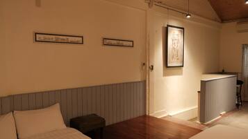 A bedroom with a wooden headboard, a small bedside table, and a framed map on the wall.