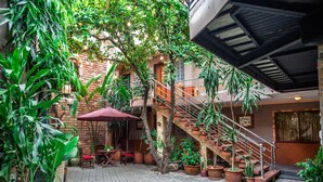 A courtyard with a brick staircase, potted plants, and outdoor seating. - Vien Ngoc Xanh 1 Hotel (Ho Chi Minh City)