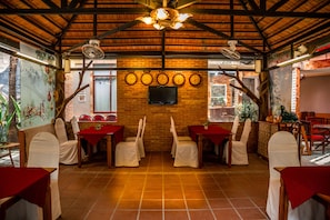 Enjoy dining in this cozy restaurant with a brick wall, flat-screen TV, and wooden tables.
