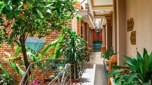 A corridor with a staircase, potted plants, and a brick wall. - Vien Ngoc Xanh 1 Hotel (Ho Chi Minh City)