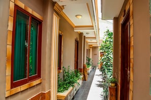 Stroll through the beautifully appointed corridor, lined with doors and windows, and surrounded by lush greenery.