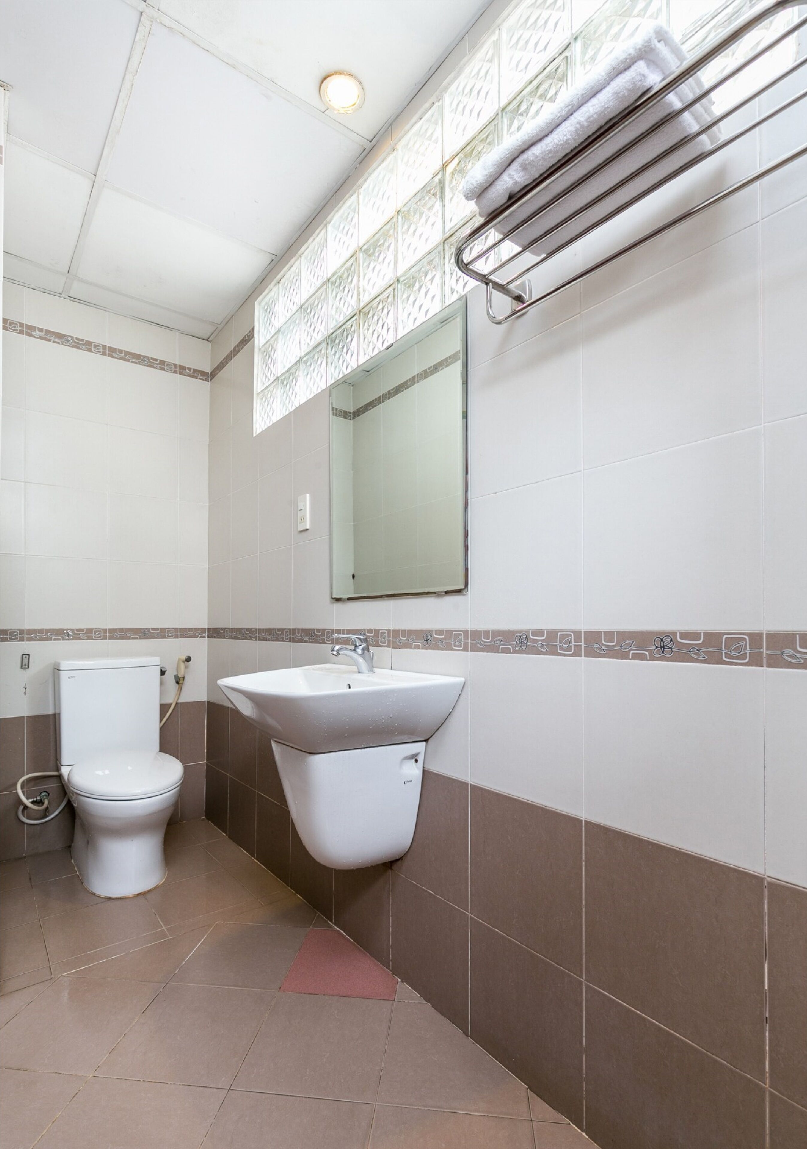 A bathroom with a toilet, sink, and towel rack.