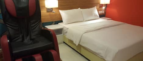 Een hotelkamer met een bed, een stoel, twee bedlampen en een nachtkastje.